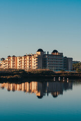 Fototapeta premium Waterfront Buildings Reflected in Calm Lake at Sunset in Spain