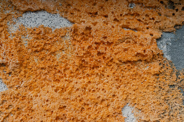 Orange textured pattern on a weathered concrete surface in a natural setting