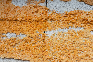 Textured wall surface featuring orange and white patterns in urban setting