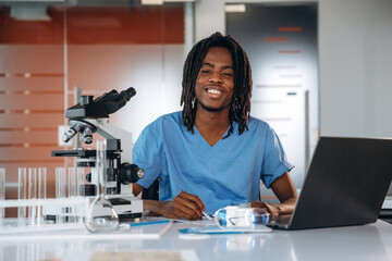 The microscope on the table. Black man doctor is in the office