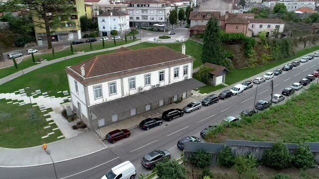 Drone shot of a white building in Fafe, surrounded by cars and other houses in the back.