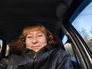 Middle-aged woman captures a joyful moment while traveling in her car during an exciting road trip