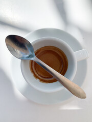 Top view of an espresso cup with a metal spoon resting on the rim.