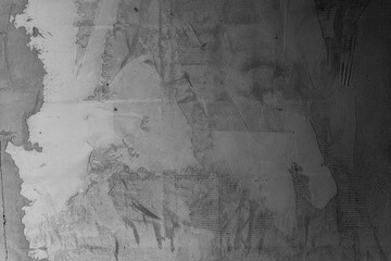 Textured concrete wall with peeling paint in grayscale tones