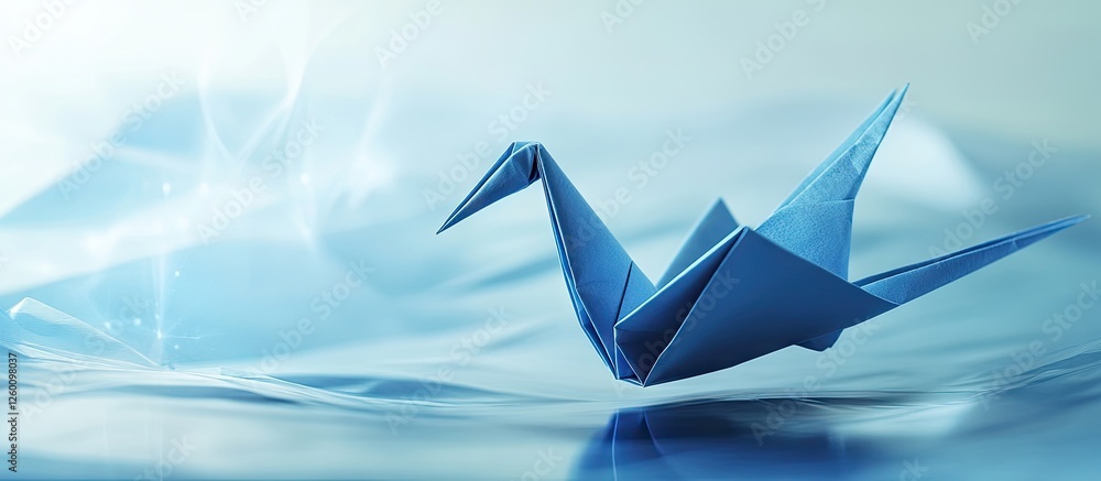 Leinwandbilder blue origami crane resting elegantly on soft blue fabric with a light gradient background creating a