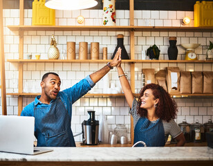Small business, waiter and high five celebration in coffee shop for teamwork, sale target or...