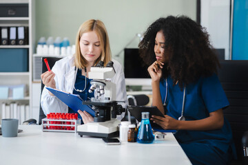 Scientists conducting research in a biotechnology lab, using pipettes and test tubes for medical...