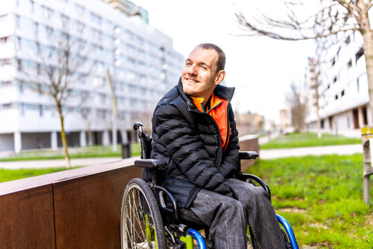 Portrait of disabled man smiling in wheelchair in urban park