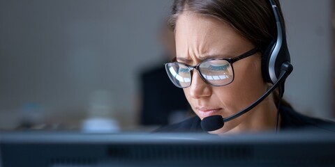 Stressed Call Center Operator with Headset. A call center operator appears stressed while handling calls, illustrating the challenges and demands of customer service in a busy work environment.