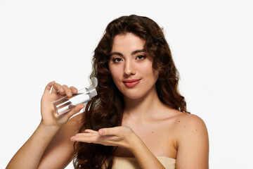 Stylish young woman showcases skincare routine in bright studio setting © LIGHTFIELD STUDIOS