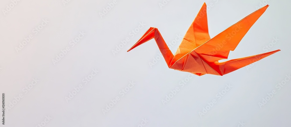 Poster orange origami crane flying in upper left corner on a soft white background with a smooth gradient f