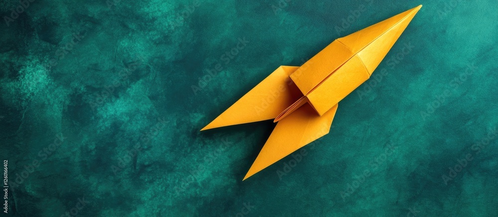 Aufkleber handmade yellow origami rocket centered on a textured green background with a smooth finish and subt