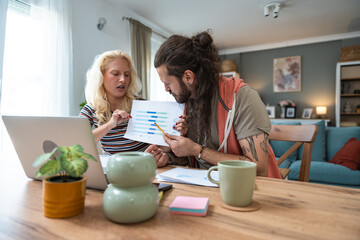 Finance and economy. Young couple, small business owners, working online at home office, preparing for video call for presentation and online coaching. E-commerce man and woman professional occupation