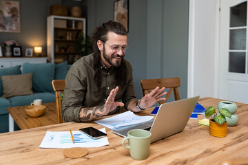 Finance and economy. Young man, small business owner, working online at home office, preparing for video call for presentation and online coaching. E-commerce professional occupation freelance work