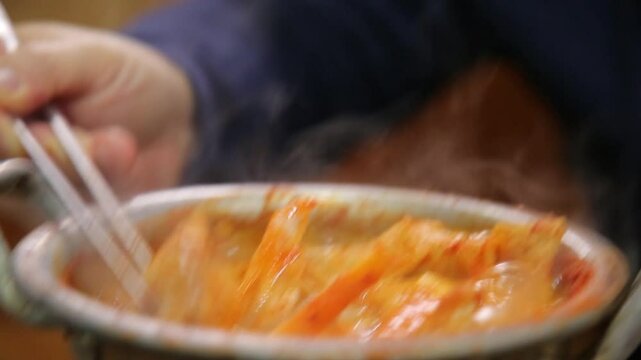Fish lifted with chopsticks from boiling codfish soup