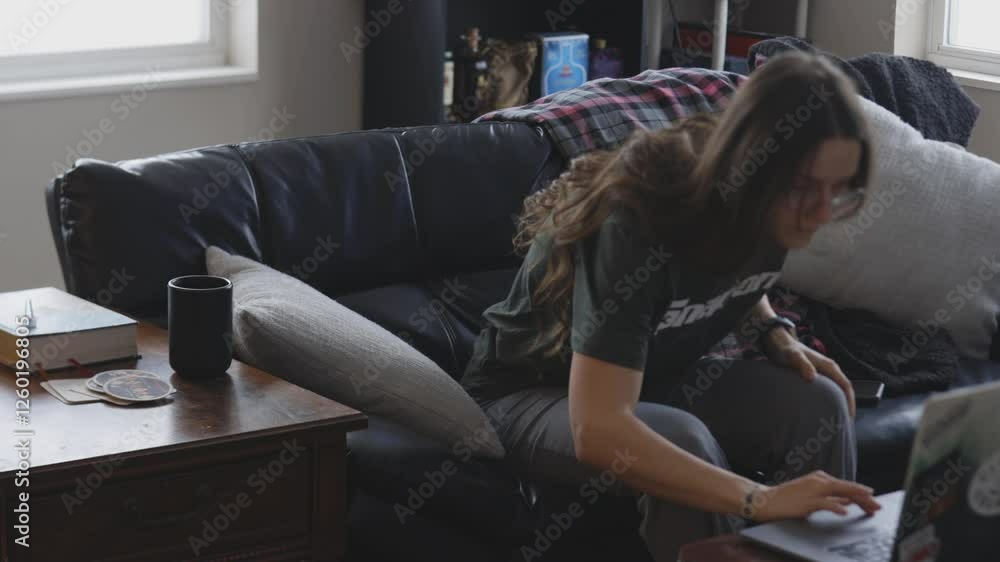 Poster remote worker engaged on a computer in an apartment.
