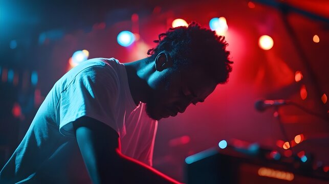 Intense musician performing live on stage, illuminated by colorful lights, creating a vibrant atmosphere