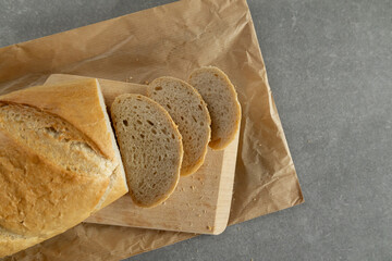 Loaf of bread on a cutting board and paper.