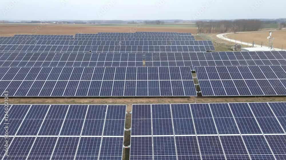 Poster an extensive solar farm featuring rows of photovoltaic panels installed on open farmland. the solar 