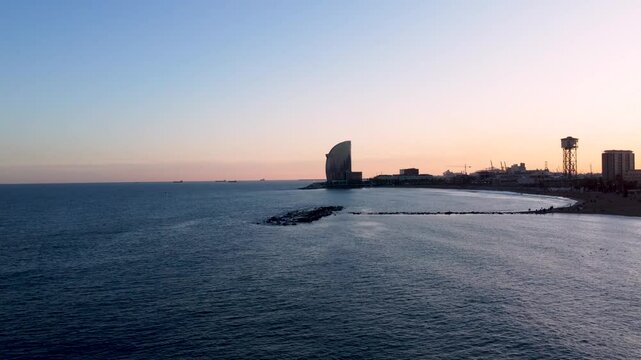Aerial hyperlapse Barcelona beach at sunset. Dusk cityscape near Barceloneta beach. Timelapse of sunset skyline. Marina street and Port Olimpic