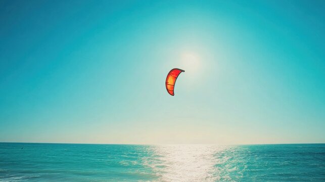 Vibrant photo of a kiteboarding scene on a sunny day. Clear blue sky and calm water creating a thrilling atmosphere. Emphasizing sport and freedom. Perfect for water sports and adventure content.