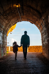 Father and daughter in pedestrian tunnel through a rock or mountain near Petrovac town in winter...