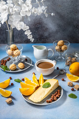 Delicious breakfast with coffee, cheese, orange slices, nuts and cookies