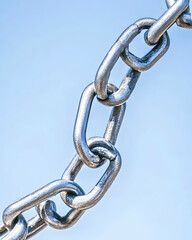 Obraz premium Metal chain against blue sky represents strength, connection for industrial use