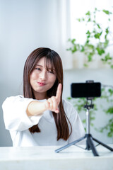 動画撮影で指をさす日本人女性