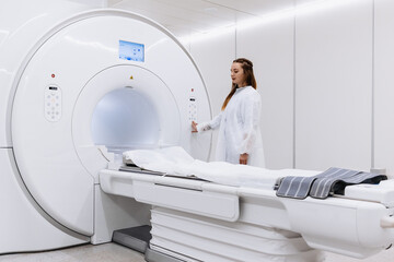 A professional radiologist in uniform preparing the MRI scanning process in a clinic. MRI or CT...