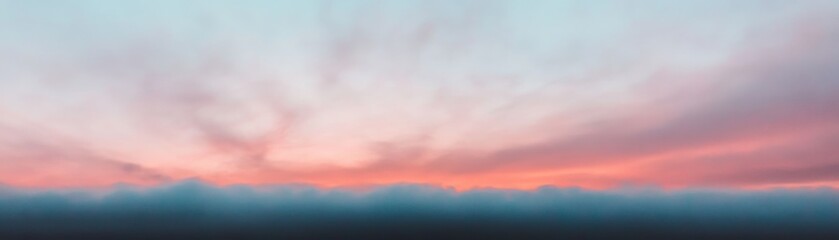 Obraz premium A serene landscape featuring a pastel sky at dawn, with soft hues of pink and blue blending seamlessly above a tranquil horizon.