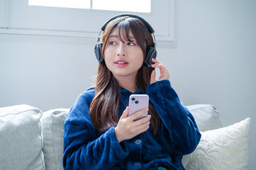 ヘッドホンで音楽を聴く日本人女性