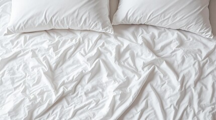rumpled white linens: an unmade bed with soft sheets and pillows, suggesting comfort and relaxation