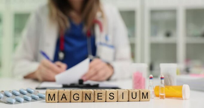 Word Magnesium with pills and vials against medical professional in lab. Doctor writes prescription for pharmaceutical products in clinic office