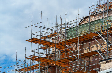scaffolding around the dome of the mosque, against the sky, to repair the exterior of buildings, or on a construction site