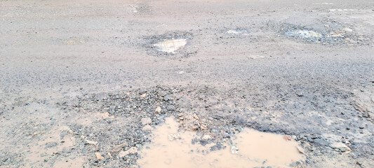 broken asphalt road. the asphalt road with potholes and waterlogged after the rain