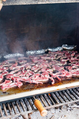 Lamb chops cooking on a smoking grill. Outdoor barbecue. Copy space. Vertical image.