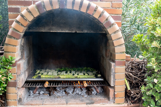 Front view of a brick grill with vegetables. Outdoor barbecue. Vegetarian food. Copy space. Horizontal image.