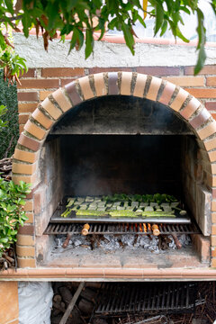 Front view of a brick grill with vegetables. Outdoor barbecue. Vegetarian food. Copy space. Vertical image.