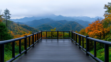 Scenic mountain vista from wood bridge in autumn with colorful trees, foggy peak