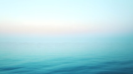Obraz premium Calm ocean waters meet a soft pastel colored misty sky