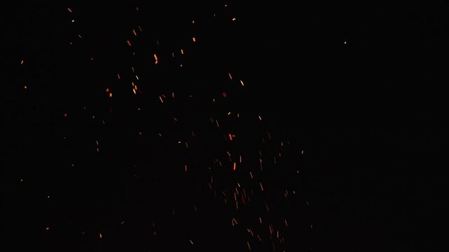 Glowing orange embers floating gently on dark black background