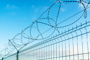 Barbed wire fence on sky background. 