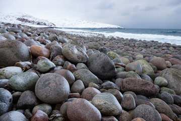 On the beach of dragon eggs on a cloudy February day. Teriberka, Murmansk region. Russia