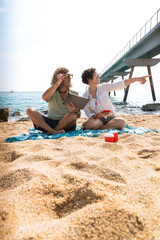 Fototapeta premium Young couple on vacation on the beach, looking for information about hotels, shopping centers and transport guides. lifestyle and travel concept.