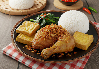 A delicious Ayam Penyet dish on a wooden table with a rustic background, featuring smashed fried chicken, rice, and sambal.