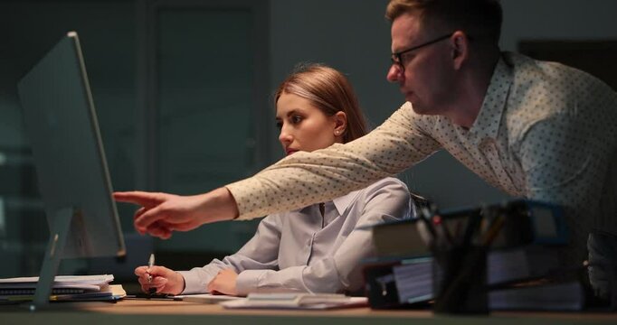 Competent businessman analyzes work of intern on computer. Man offers suggestions for improving accuracy of financial calculations. Slow motion