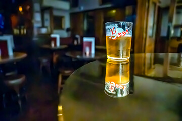 A glass of beer on the table. Bar in the blurred background with no people. 09/03/2024