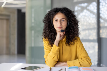 Serious woman with headset looking at camera. Web camera view, online business meeting conference....