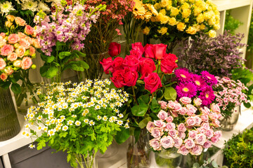 Florist arranging colorful flowers for sale at flower shop